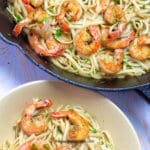 A bowl of shrimp scampi next to a pan full of more scampi.