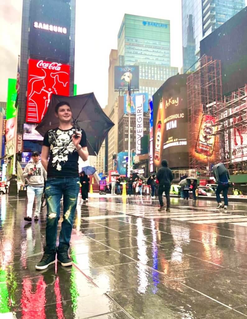 A man in the rain in Times Square, New York City.