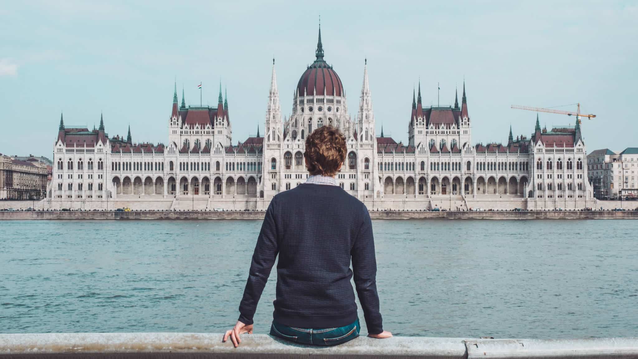 Man sitting alone in front of a castle