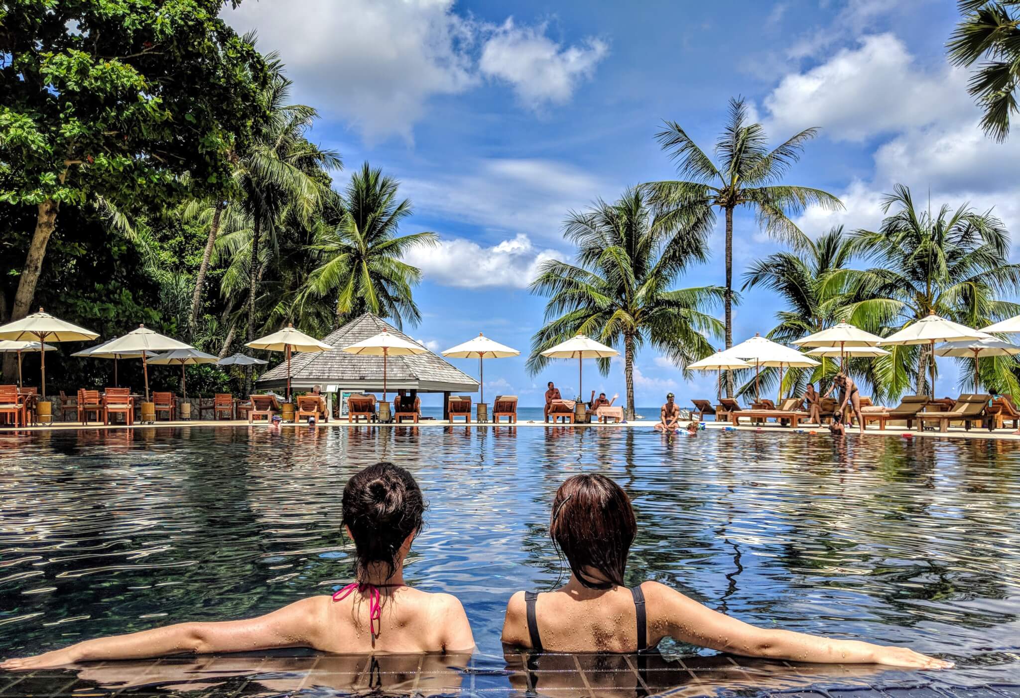 Two women sitting in a pool at a hotel