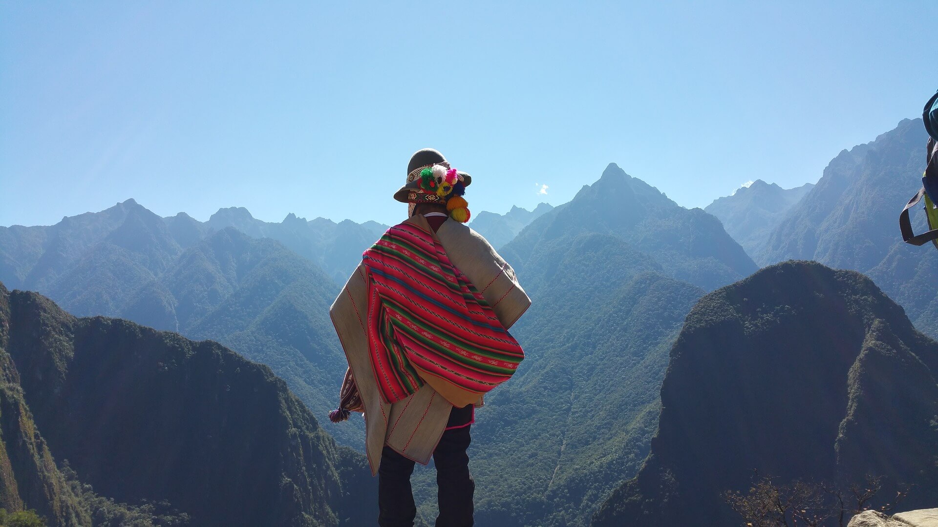 A Peruvian man looking out at the Andes mountains