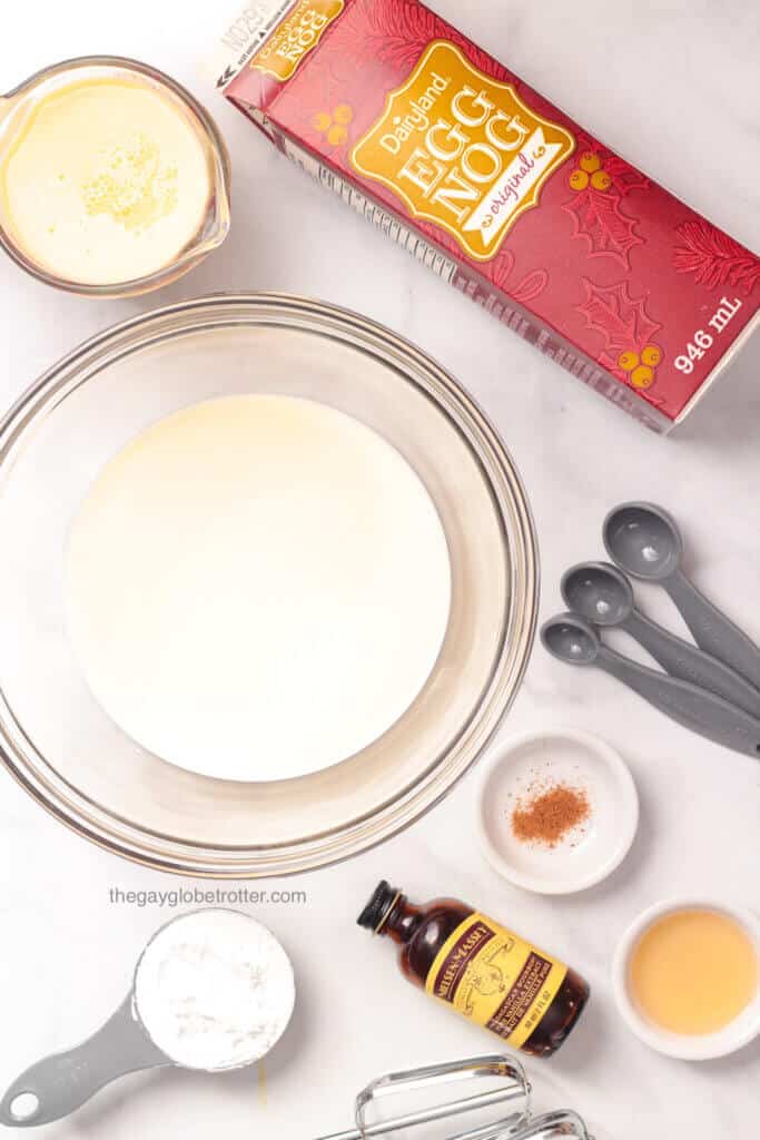 Ingredients to make eggnog whipped cream like vanilla, rum, eggnog, and heavy cream.