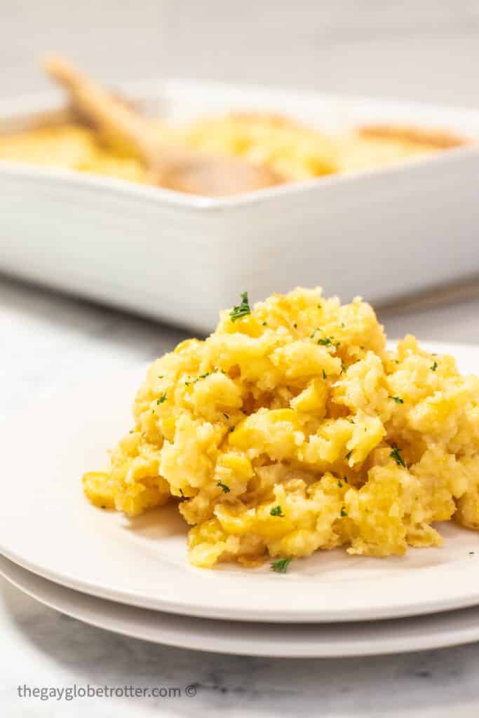 Jiffy corn casserole on a serving plate with fresh parsley.