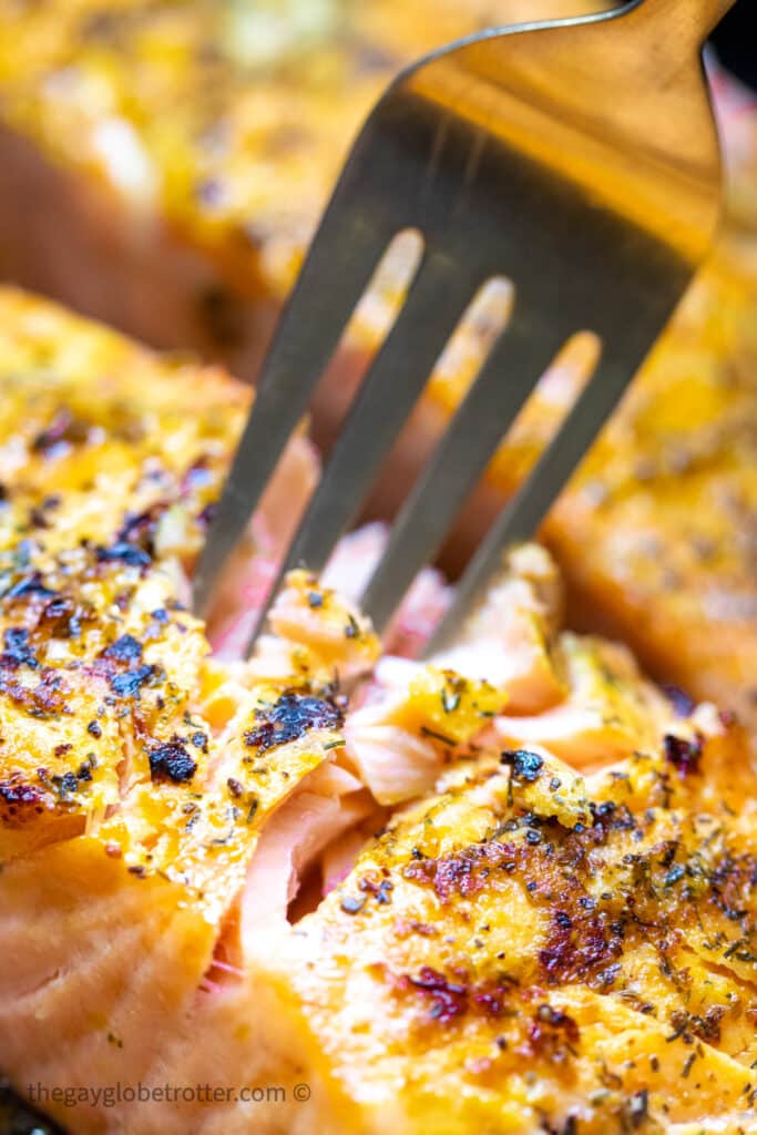 A fork taking a piece of air fryer salmon.