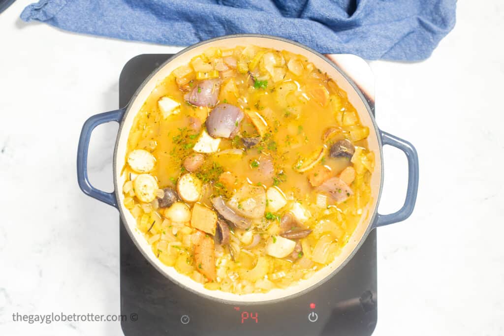 Roasted root vegetable soup simmering on a stove.