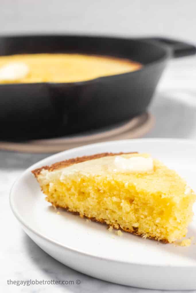 A slice of cornbread on a white plate.