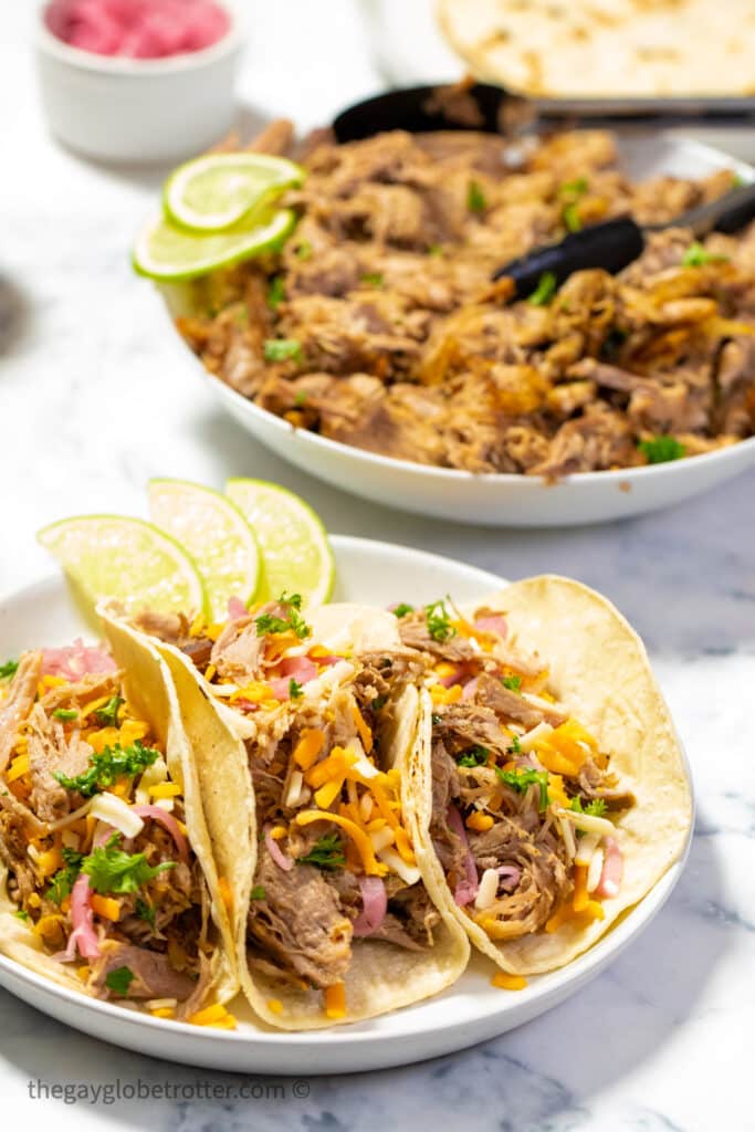 3 pork carnitas tacos on a plate.