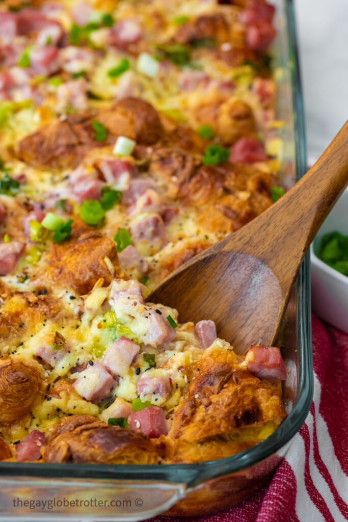 A wooden spoon serving the overnight casserole.