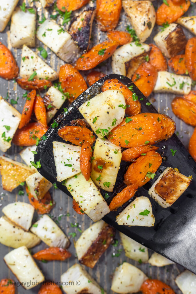 A spatula serving roasted turnips and carrots.