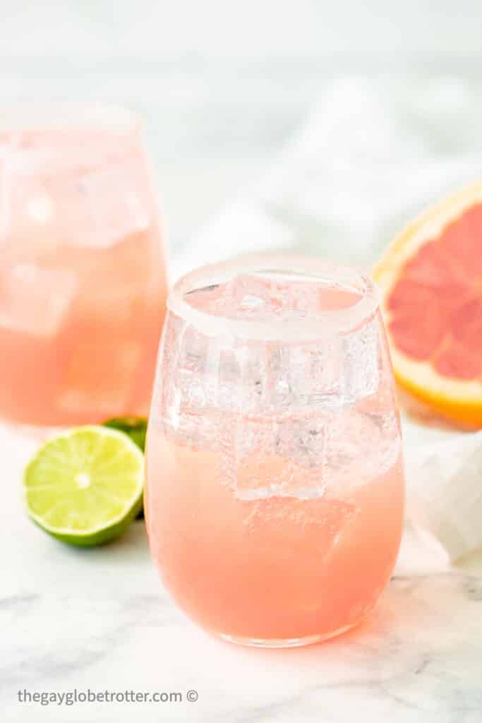 Paloma cocktails next to a lime and a grapefruit.