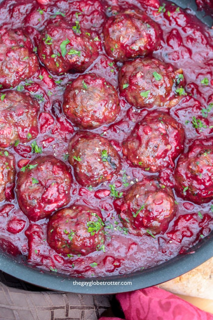 Savoury cranberry meatballs in a saucepan.