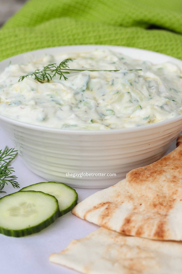 Homemade tzatziki with dill, pita bread, and cucumbers.